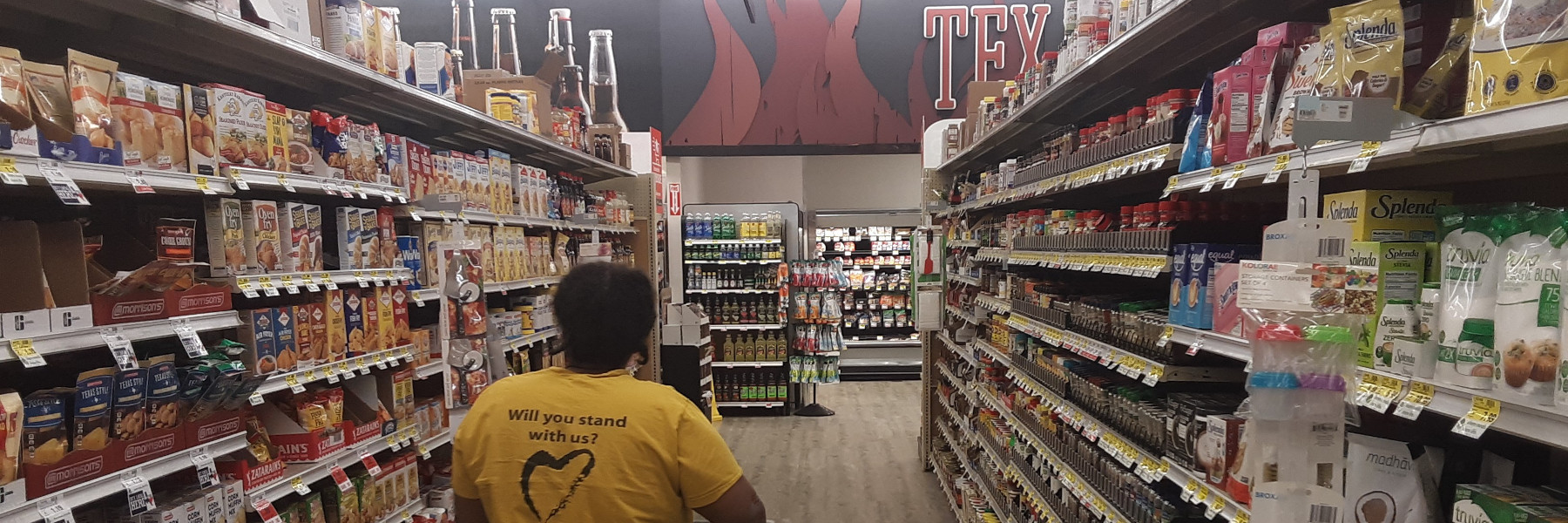 Grocery Aisle, where the Inflation Hits Rosalyn walking down an aisle in a local grocery store.