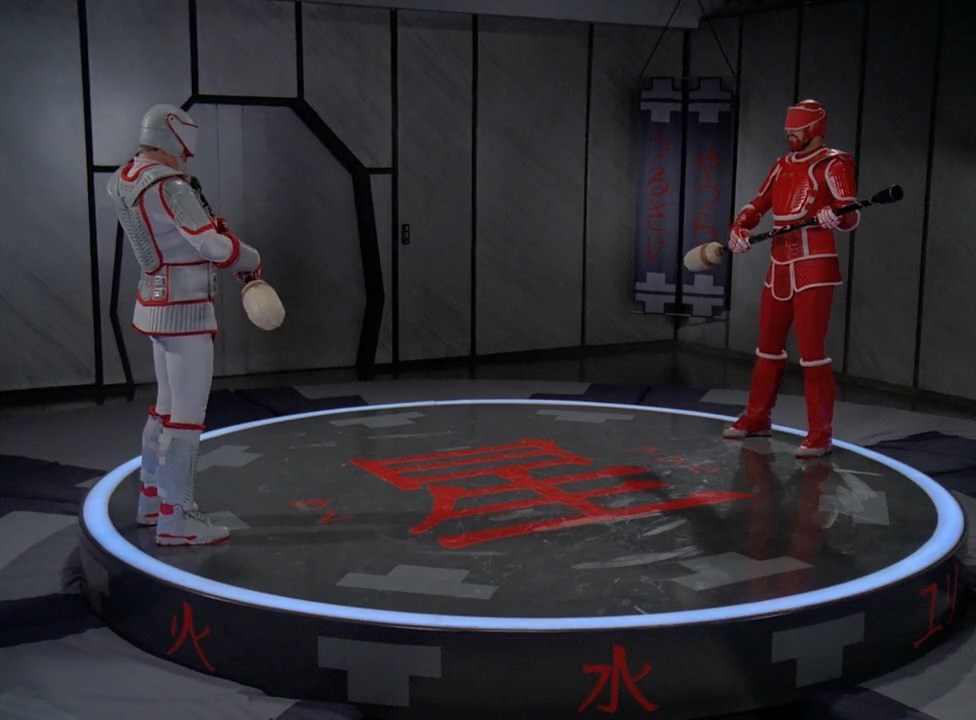 Riker and his dad in armor battle in the "Ambo Jitsu" ring.